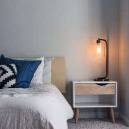 Picture of a bed next to a night stand.