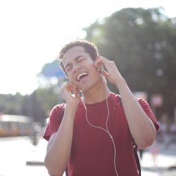 Young man listening to music through headphones.