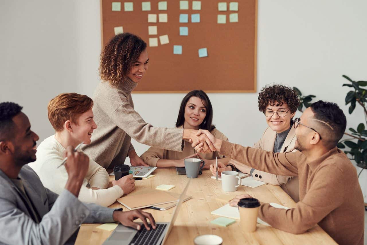 Coworkers shaking hands at a business meeting.