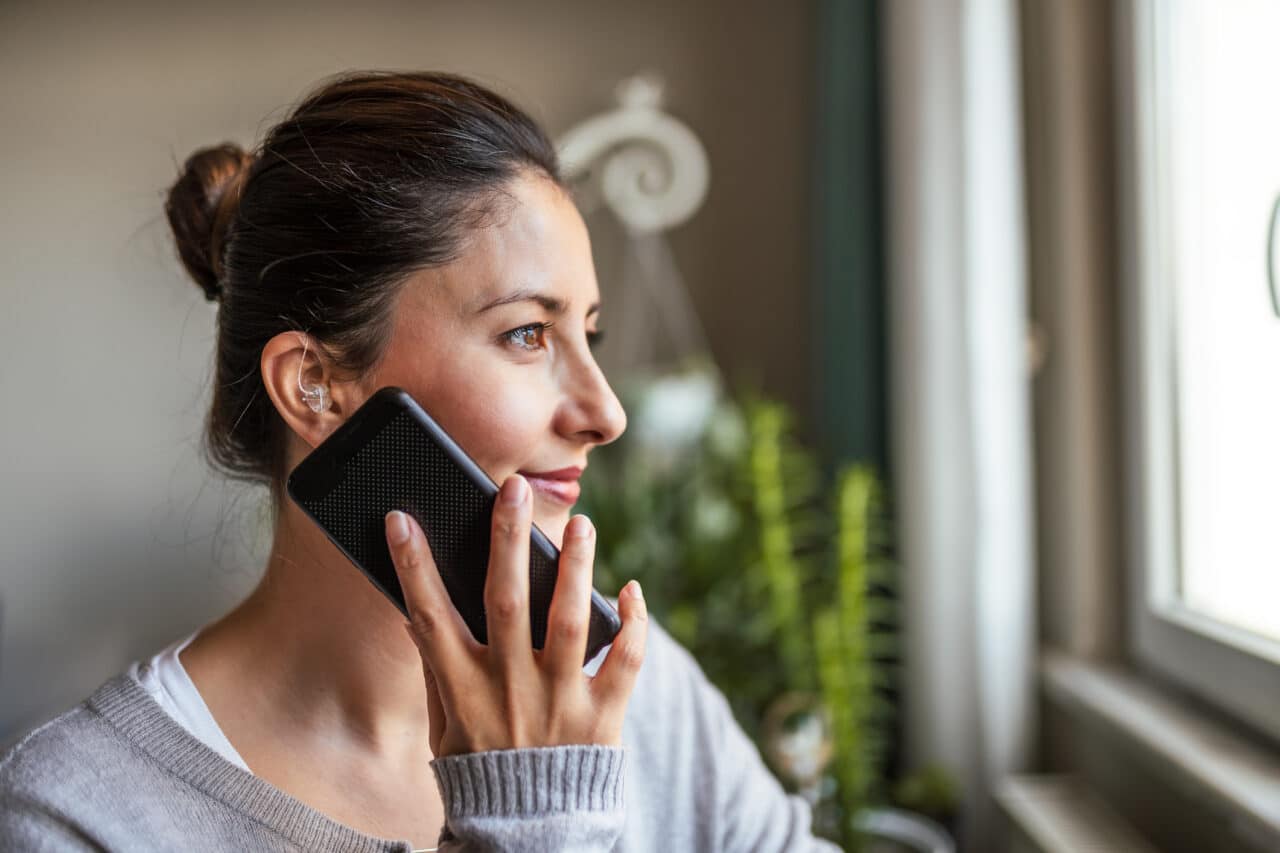 Woman with hearing aid talking on the phone.