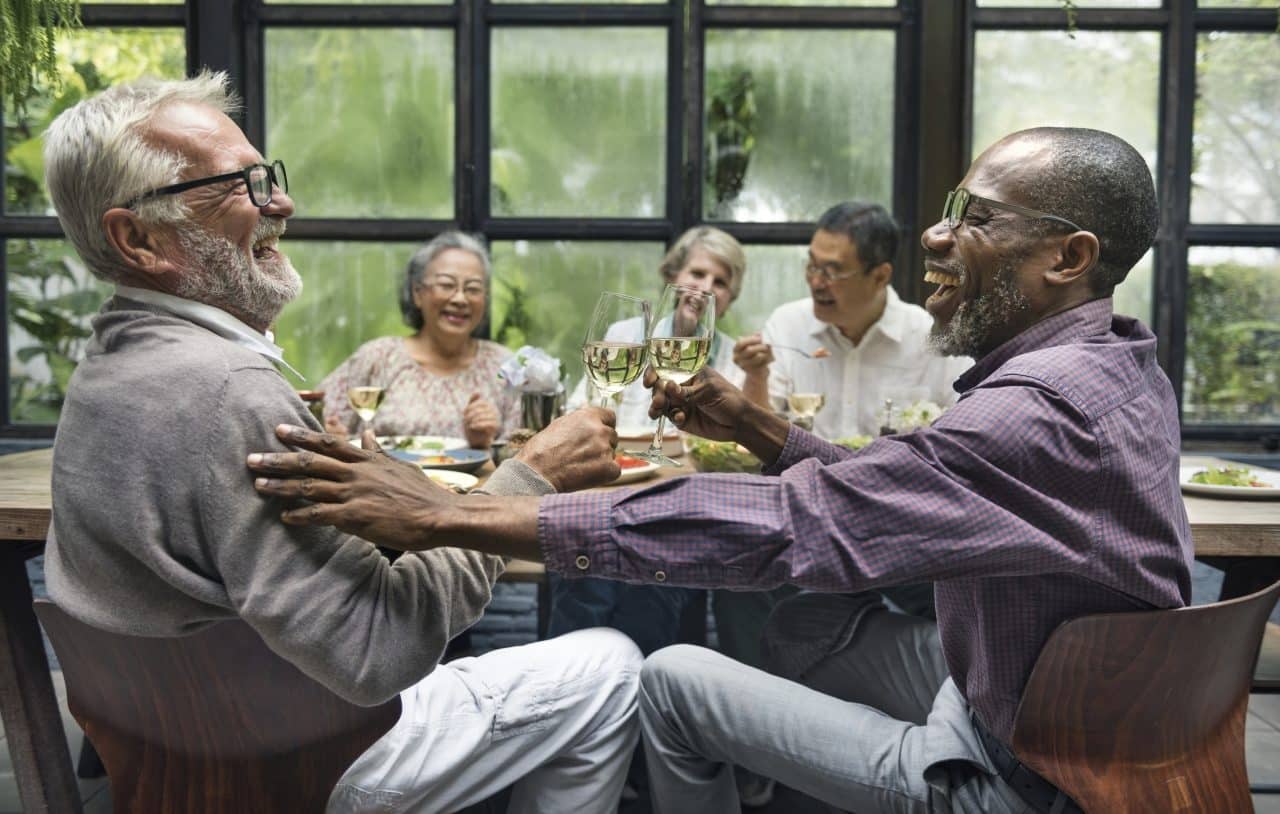 A group of older friends enjoying a dinner party together.