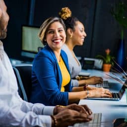 Woman smiling and chatting with her coworkers.