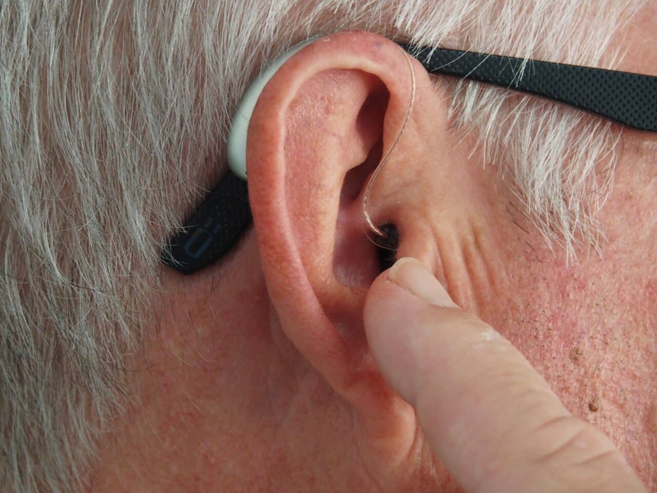 Man adjusting his hearing aid.