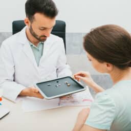 Audiologist helping a woman select a new pair of hearing aids.