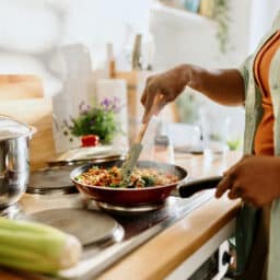 Woman mixing stir-fry at her stove.