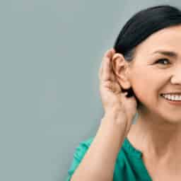 Woman holds hand to ear to hear