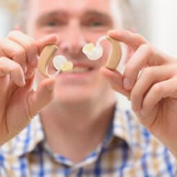 Man holds hearing aids