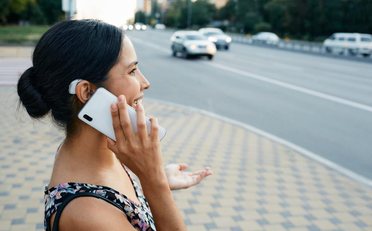 Woman talking on the phone with a hearing aid.