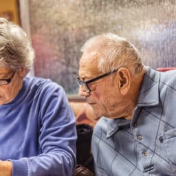 Man wearing a hearing at at a restaurant with his wife