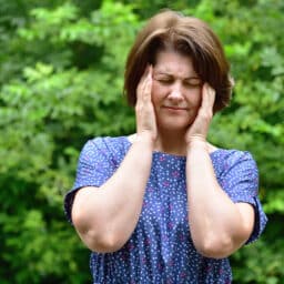 Woman holds her hands to her temples