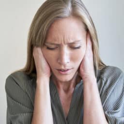 Close-up of young woman covering her ears
