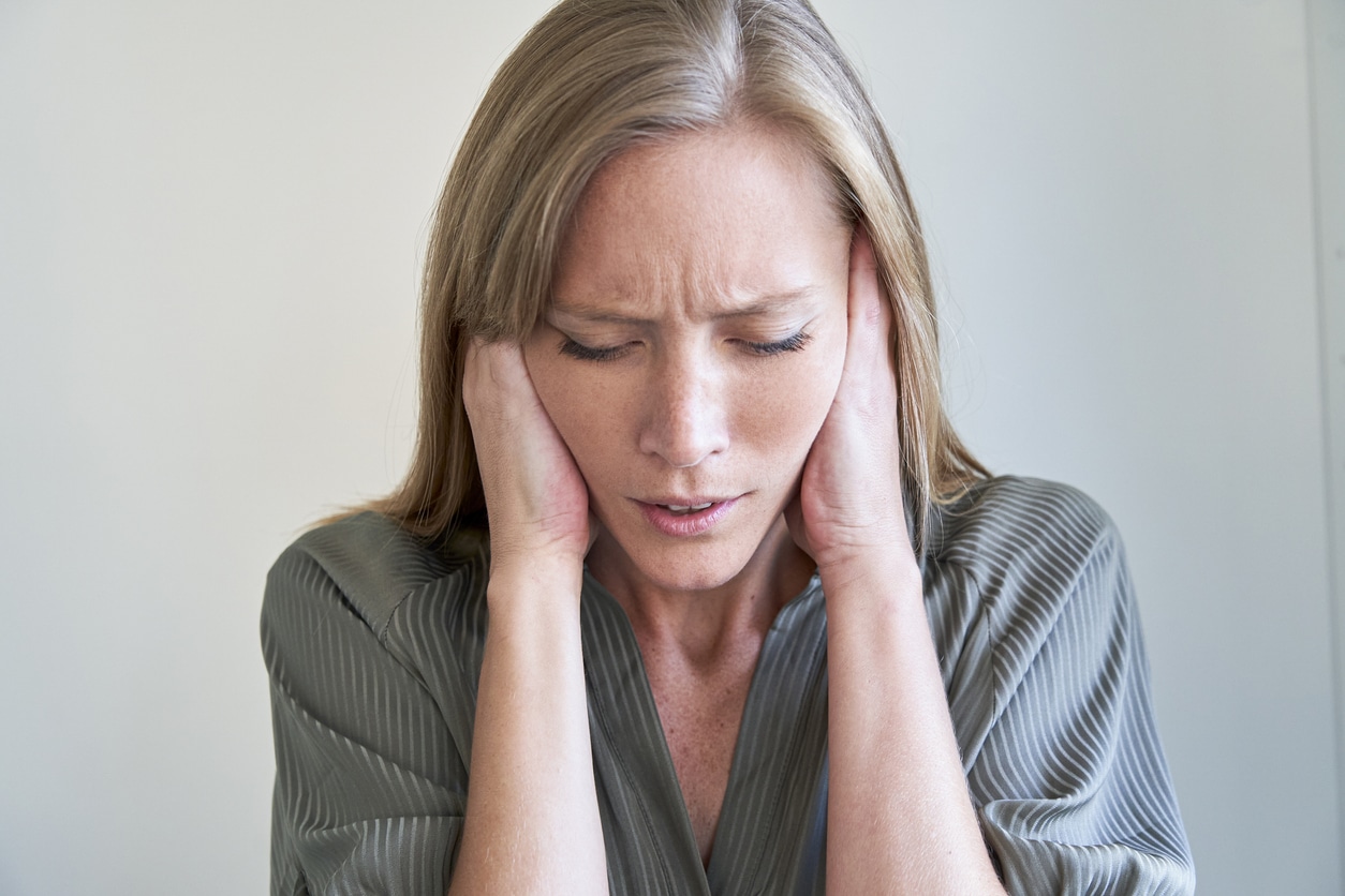 Close-up of young woman covering her ears.
