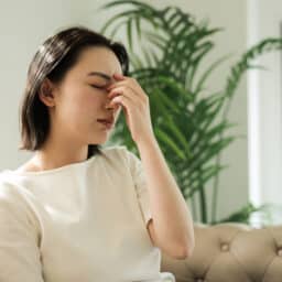 Tired woman holding her nose bridge