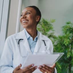Smiling doctor looking out the window in her office