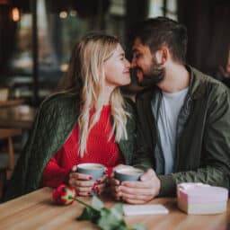Young couple touching noses and smiling at cafe