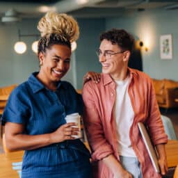 Friendly colleagues smiling and talking while having a break in an office setting