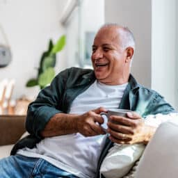 Happy senior man drinking coffee at home