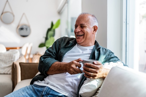 Happy senior man drinking coffee at home