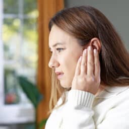 Holding my ear because of tinnitus.