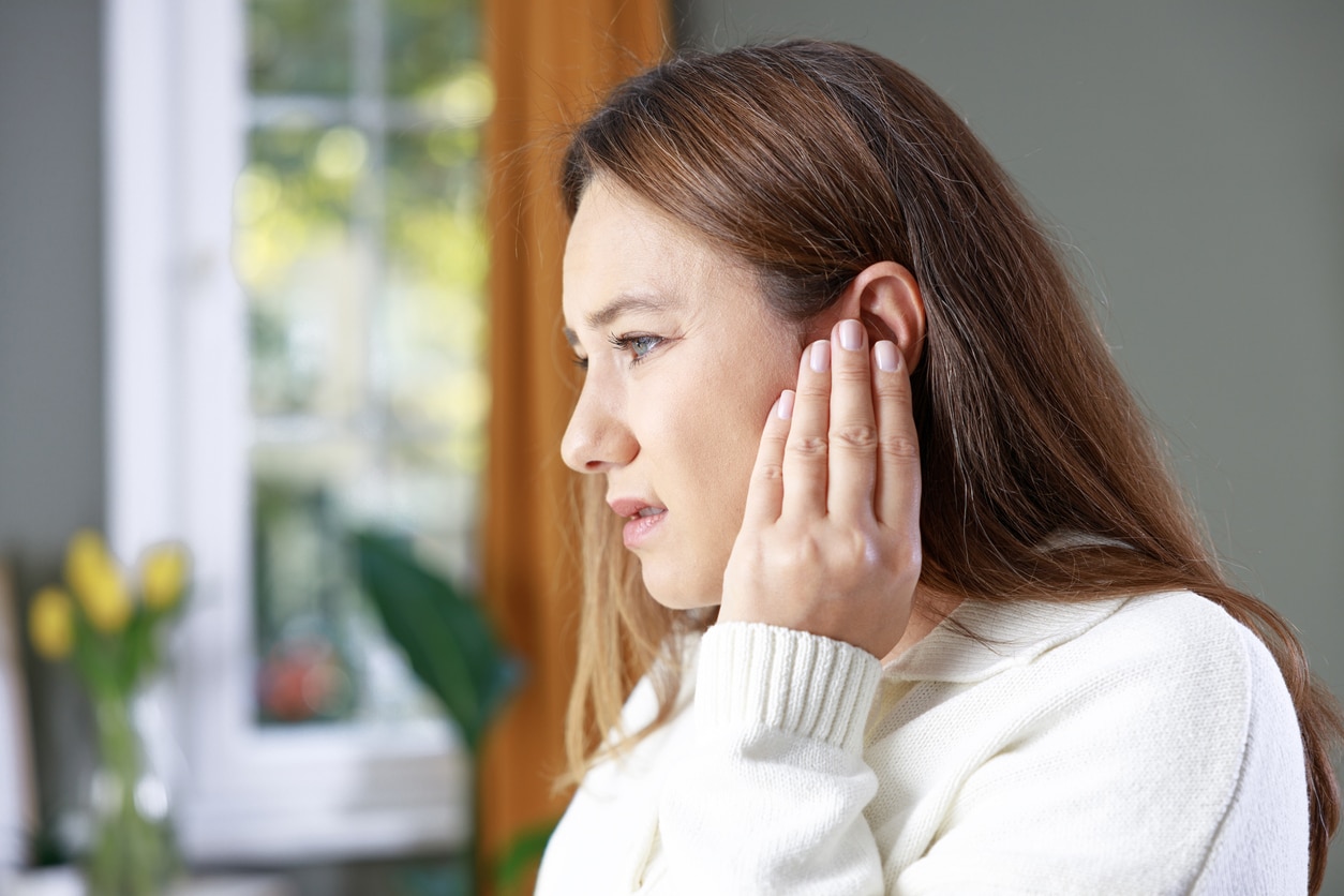 Holding my ear because of tinnitus.